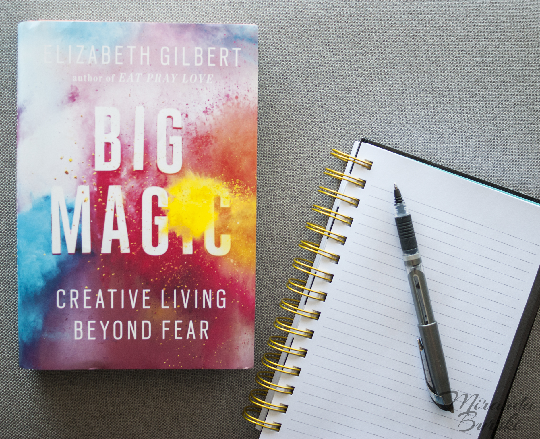 A copy of Big Magic, by Elizabeth Gilbert, beside a notebook and pen