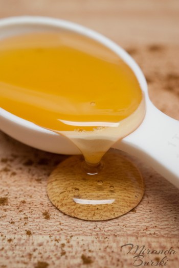 A spoonful of honey with cinnamon sprinkled around it