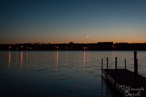 A dock and lake set against an evening sky