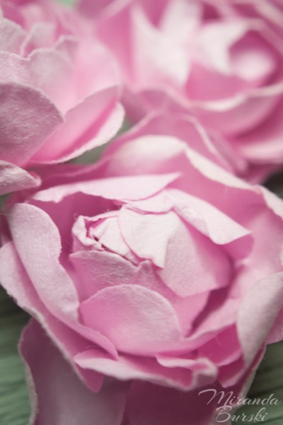 Three small, pink paper flowers