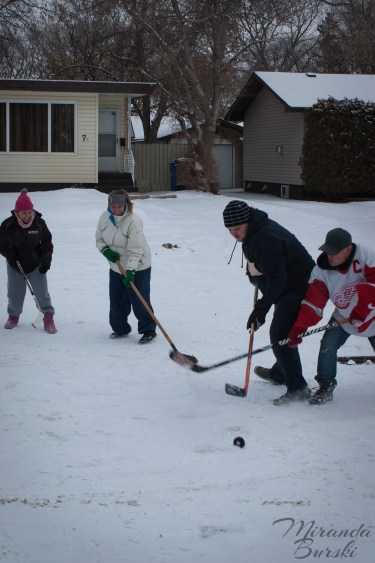Four people circling a hockey puck