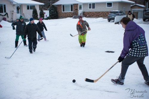 A hockey player taking a puck into a group of other players