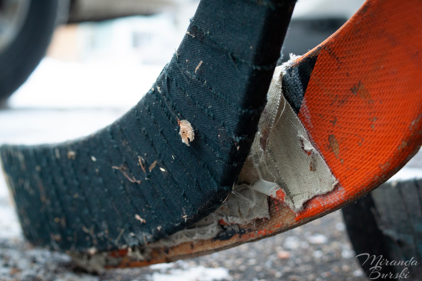 The blades of three used hockey sticks.