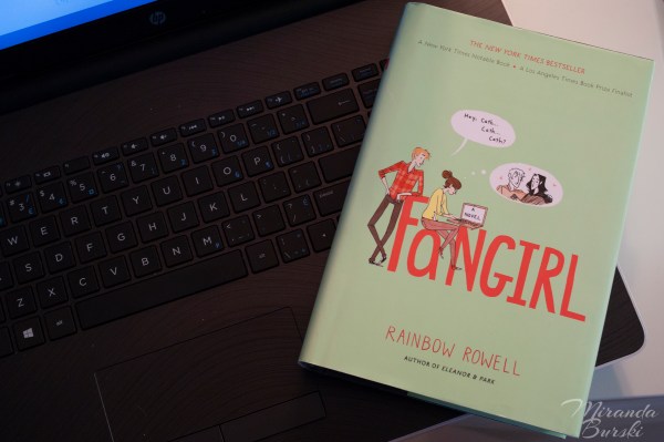 A copy of Fangirl, by Rainbow Rowell, sitting on a laptop keyboard.